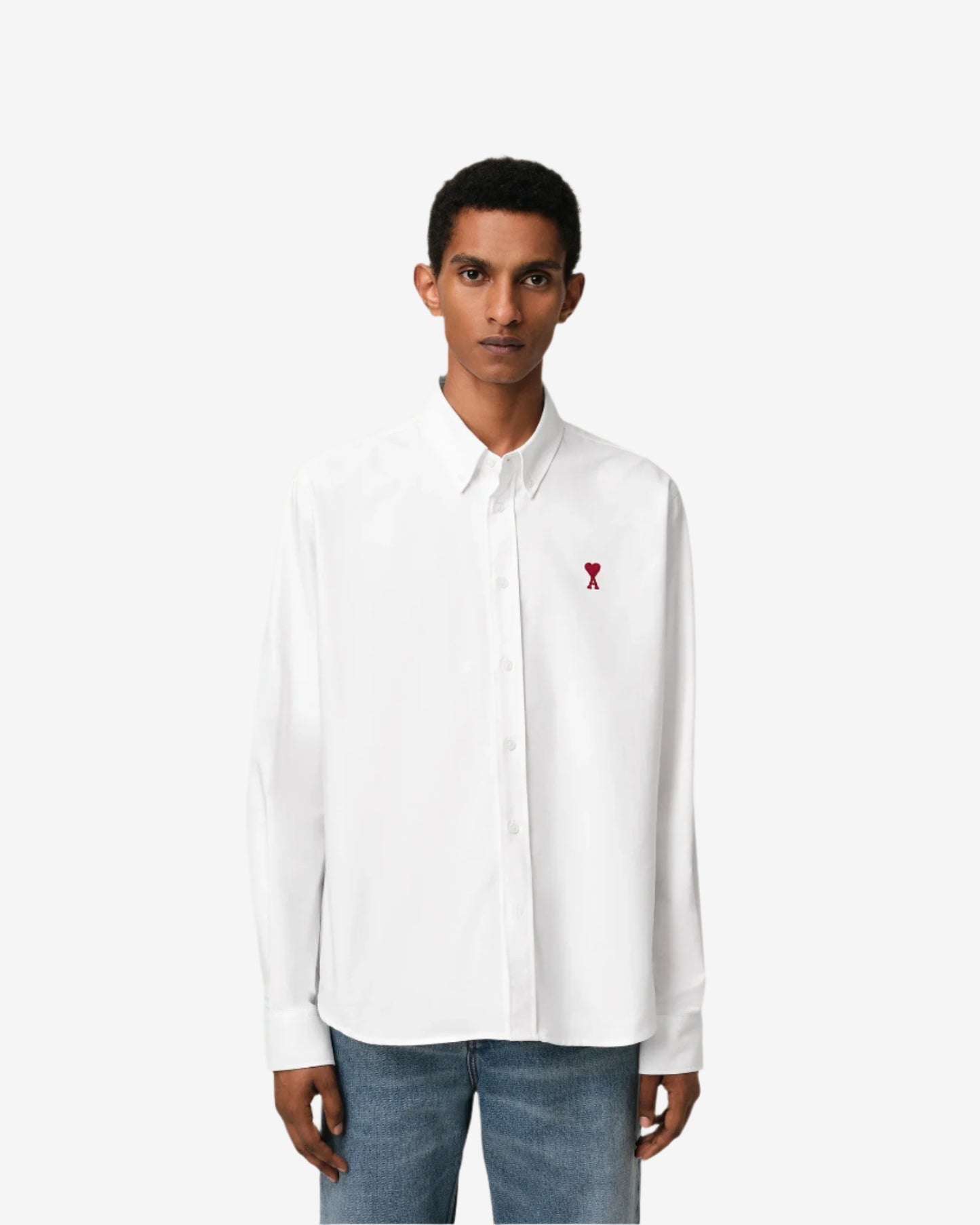 White polo shirt with a red logo on a beige background
