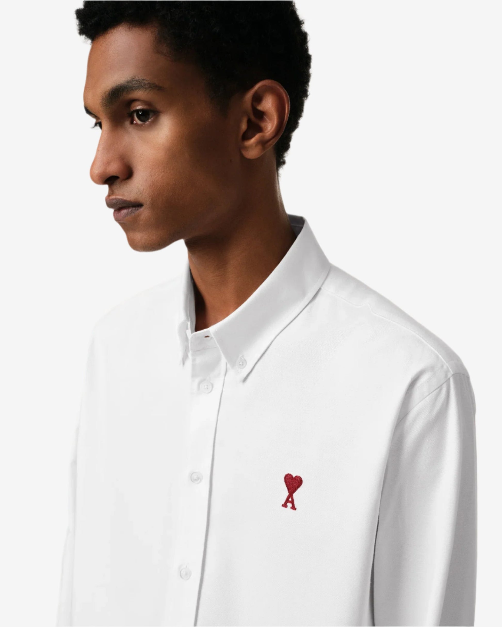 White polo shirt with a red logo on a beige background