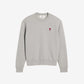 Gray sweatshirt with a small red heart design on a beige background