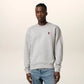 Gray sweatshirt with a small red heart design on a beige background