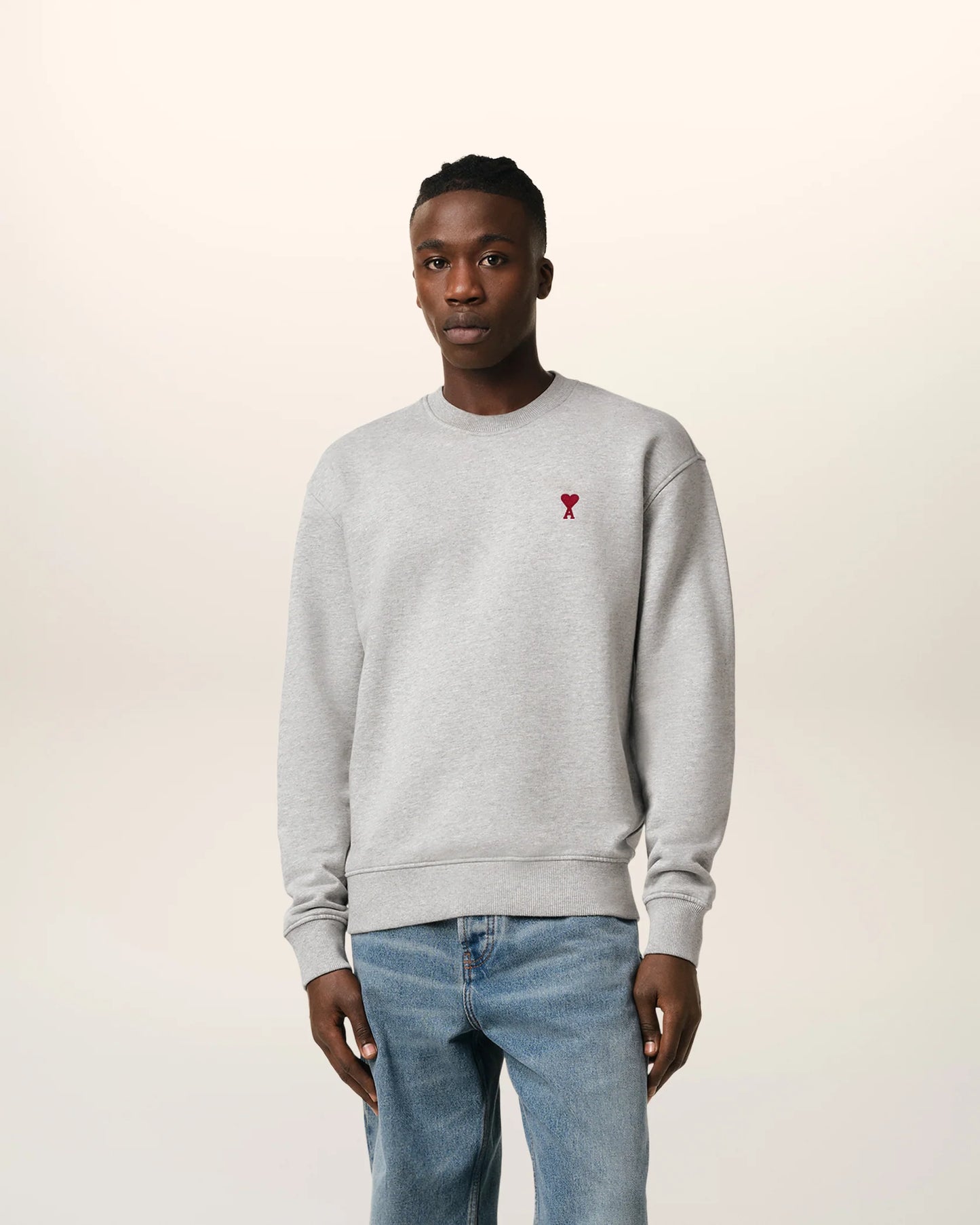 Gray sweatshirt with a small red heart design on a beige background