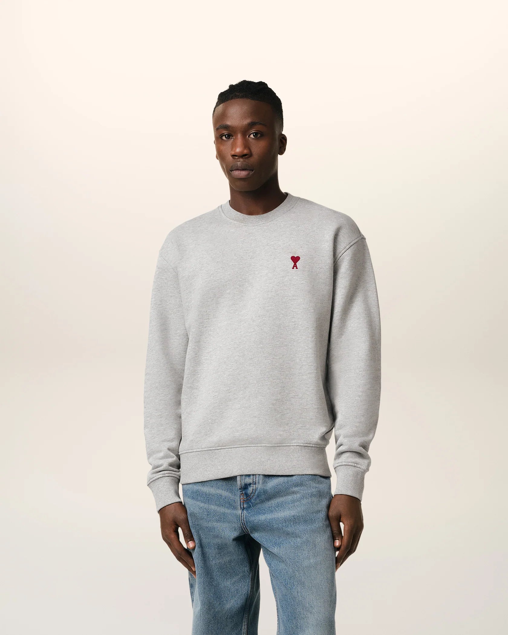 Gray sweatshirt with a small red heart design on a beige background