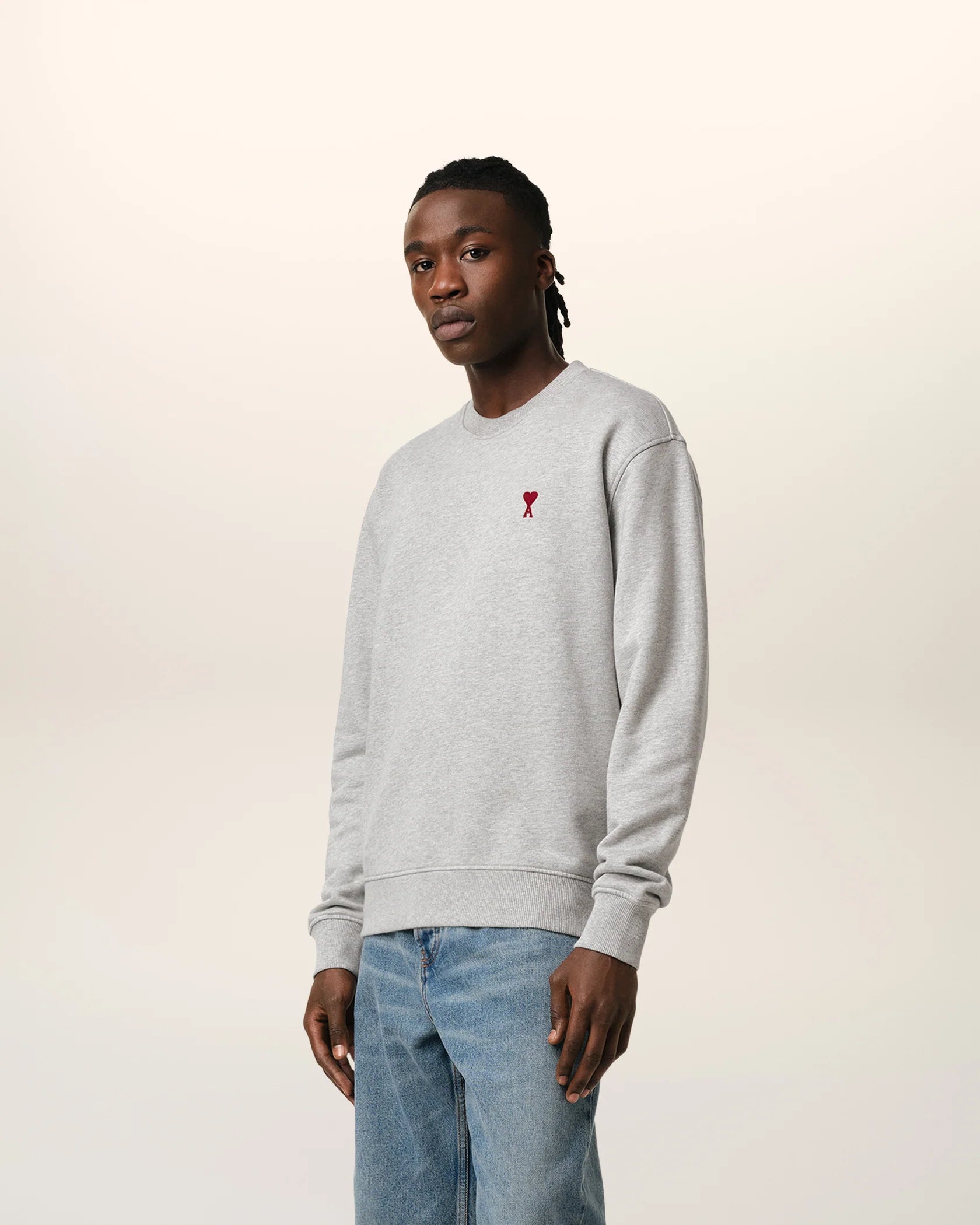Gray sweatshirt with a small red heart design on a beige background