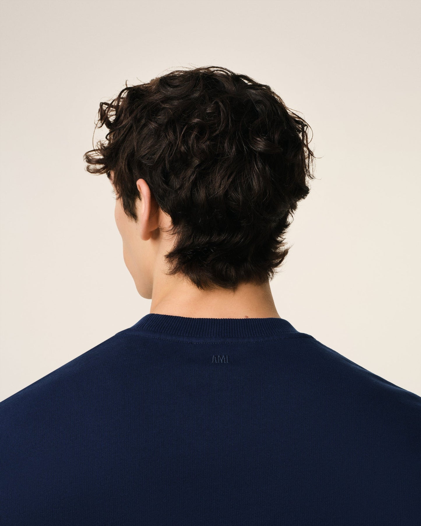 Navy blue sweatshirt with a red logo on a beige background ami paris