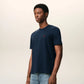 Navy blue t-shirt with a small red logo on a beige background ami paris