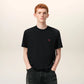 Black t-shirt with a small red logo on a beige background ami paris