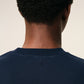 Navy blue t-shirt with a small red logo on a beige background ami paris