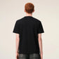 Black t-shirt with a small red logo on a beige background ami paris