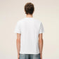 White t-shirt with a small red logo on a beige background Ami paris