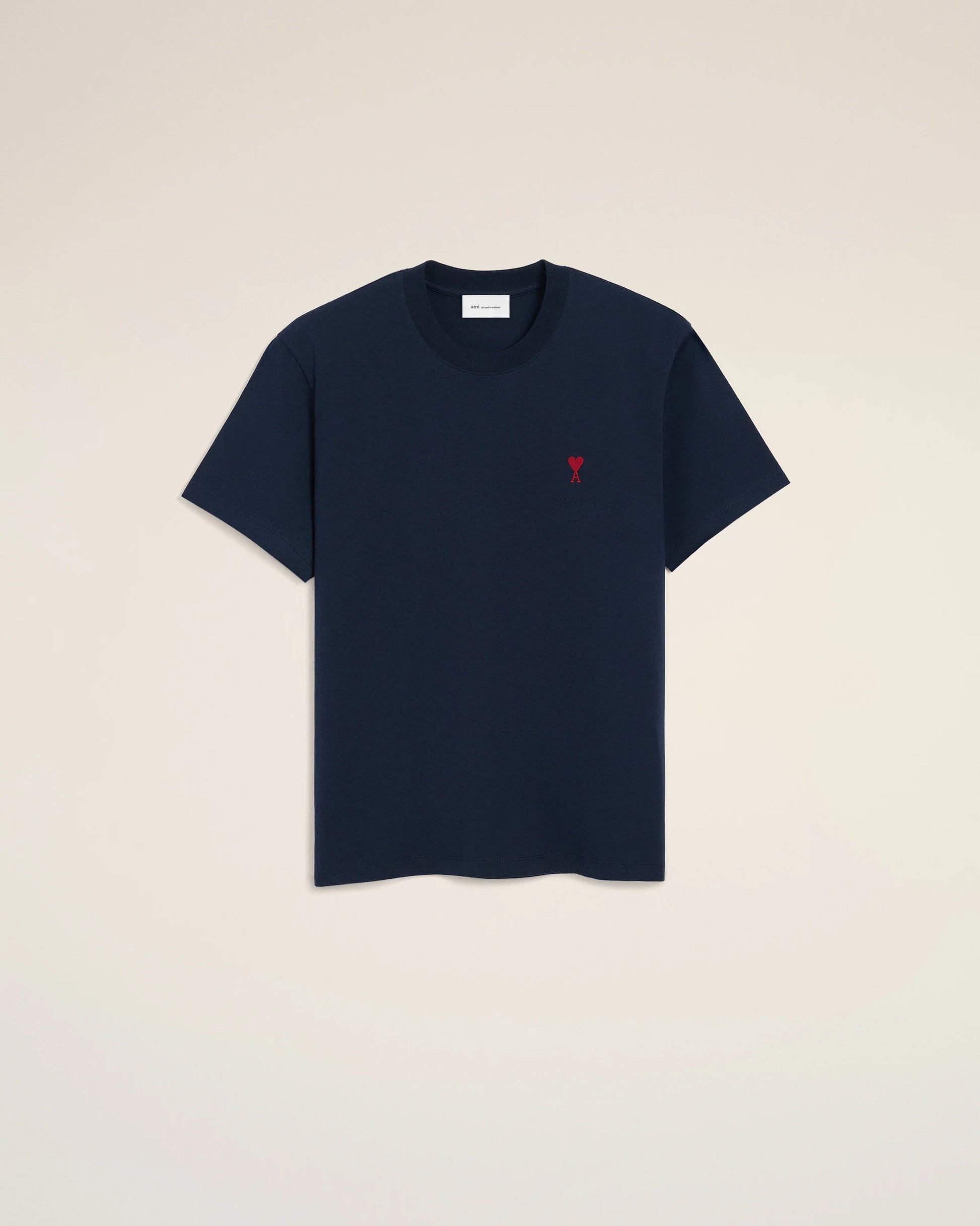 Navy blue t-shirt with a small red logo on a beige background ami paris
