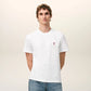 White t-shirt with a small red logo on a beige background Ami paris