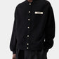 Black varsity jacket with a logo on the chest against a white background