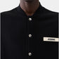 Black varsity jacket with a logo on the chest against a white background
