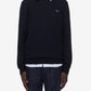 Person wearing a navy sweater with a white collar and pinstripe pants on a white background