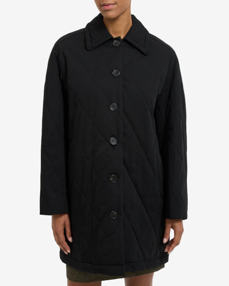 Black coat worn by a person on a white background