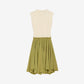 Two-tone dress with cream top and green skirt on a light beige background