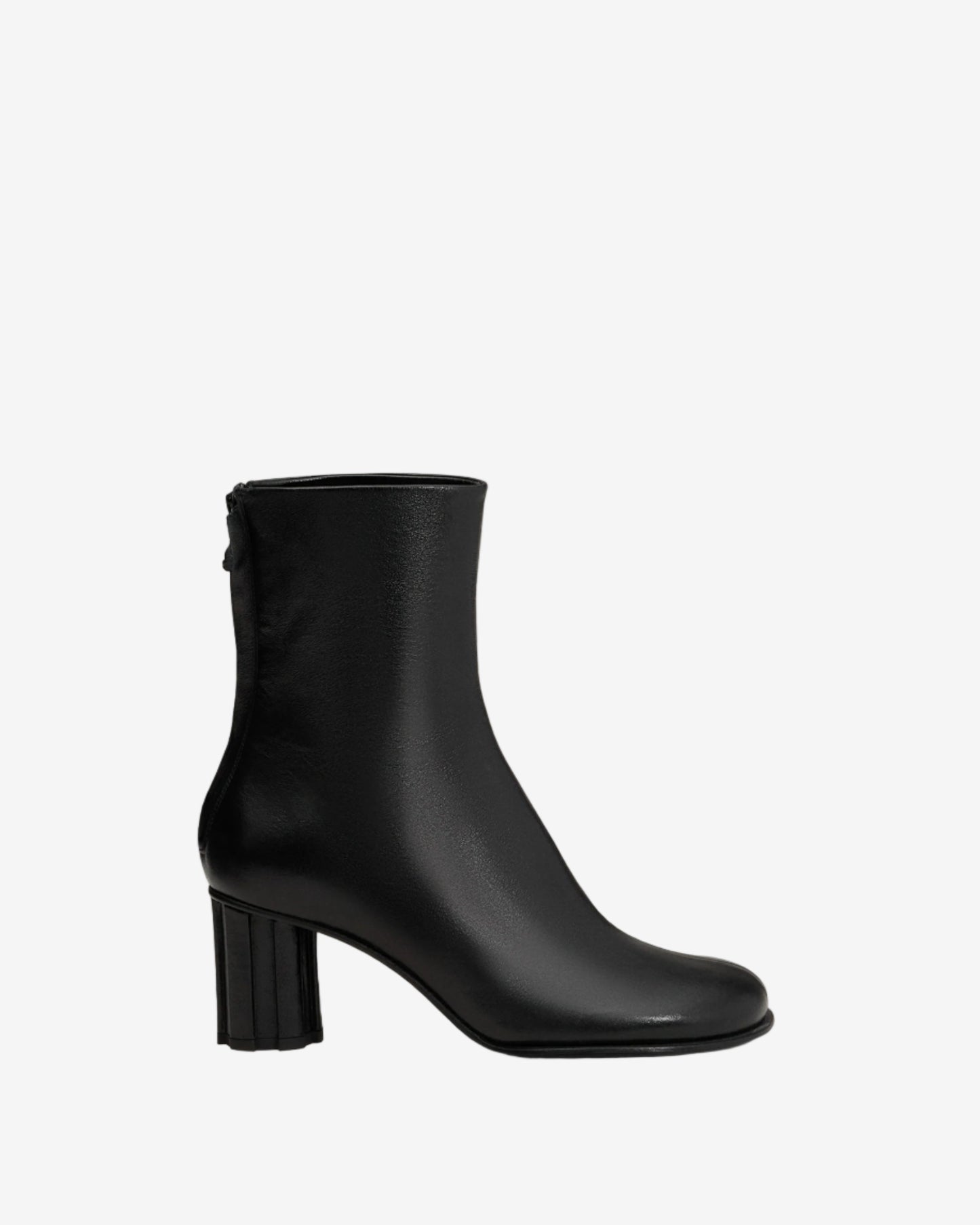 Black ankle boot on a light beige background