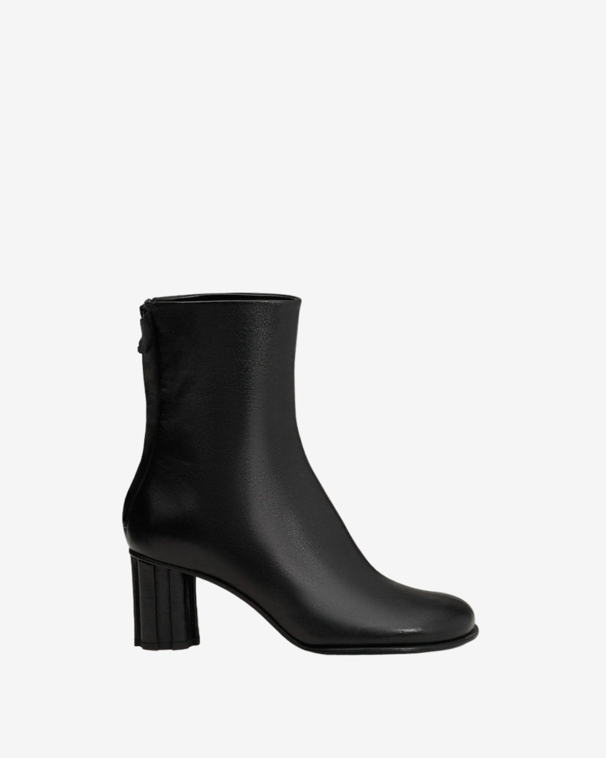 Black ankle boot on a light beige background