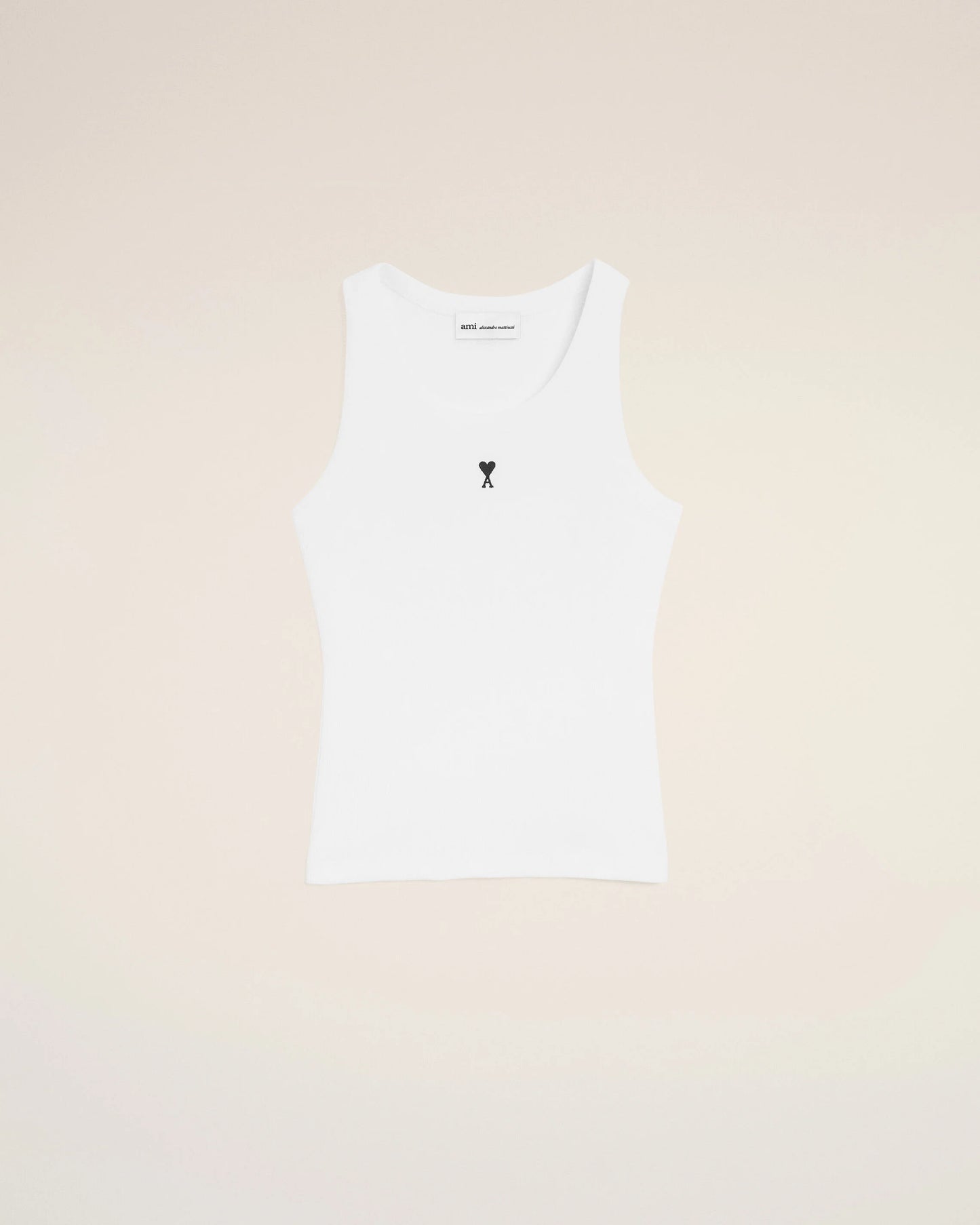 White tank top with a small black design on a beige background
