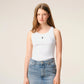 White tank top with a small black design on a beige background