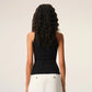Black tank top with a small white logo on a beige background