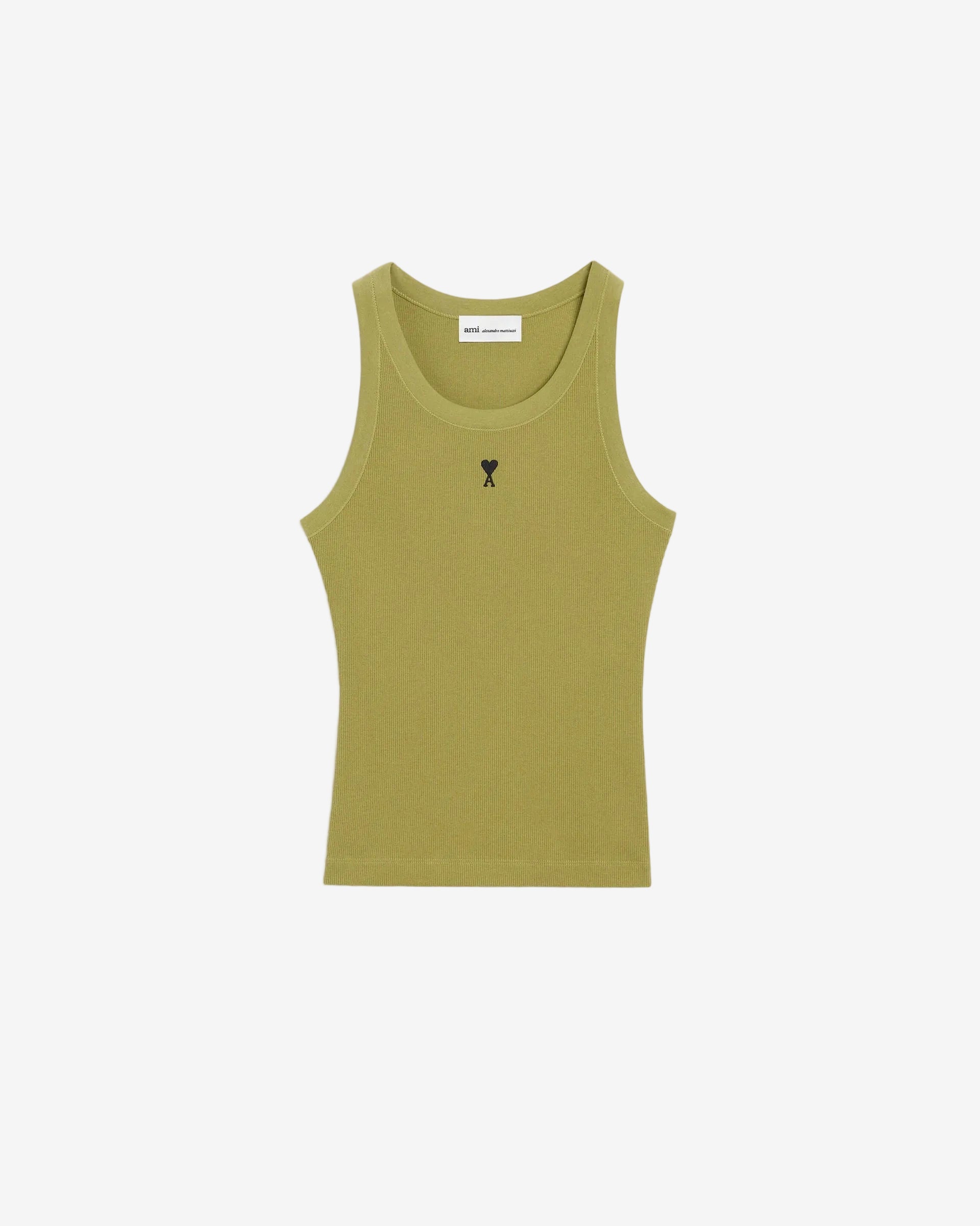 Green tank top with a small black logo on a beige background