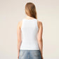 White tank top with a small black design on a beige background