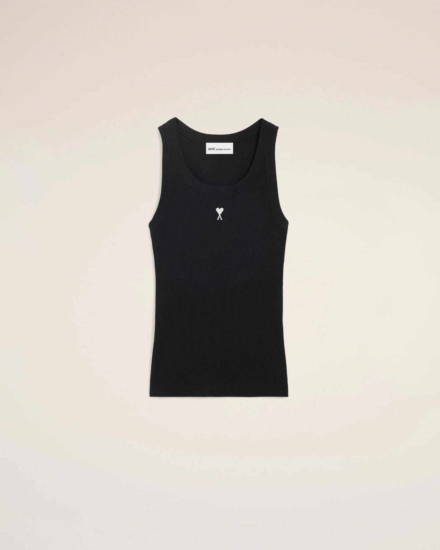 Black tank top with a small white logo on a beige background
