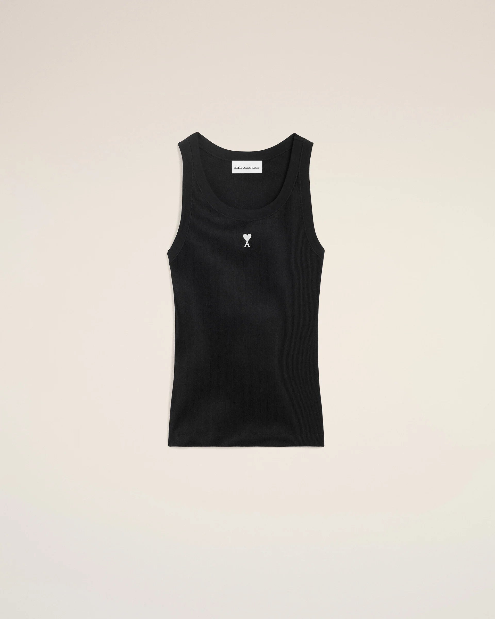 Black tank top with a small white logo on a beige background