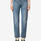 Person wearing blue jeans on a plain background