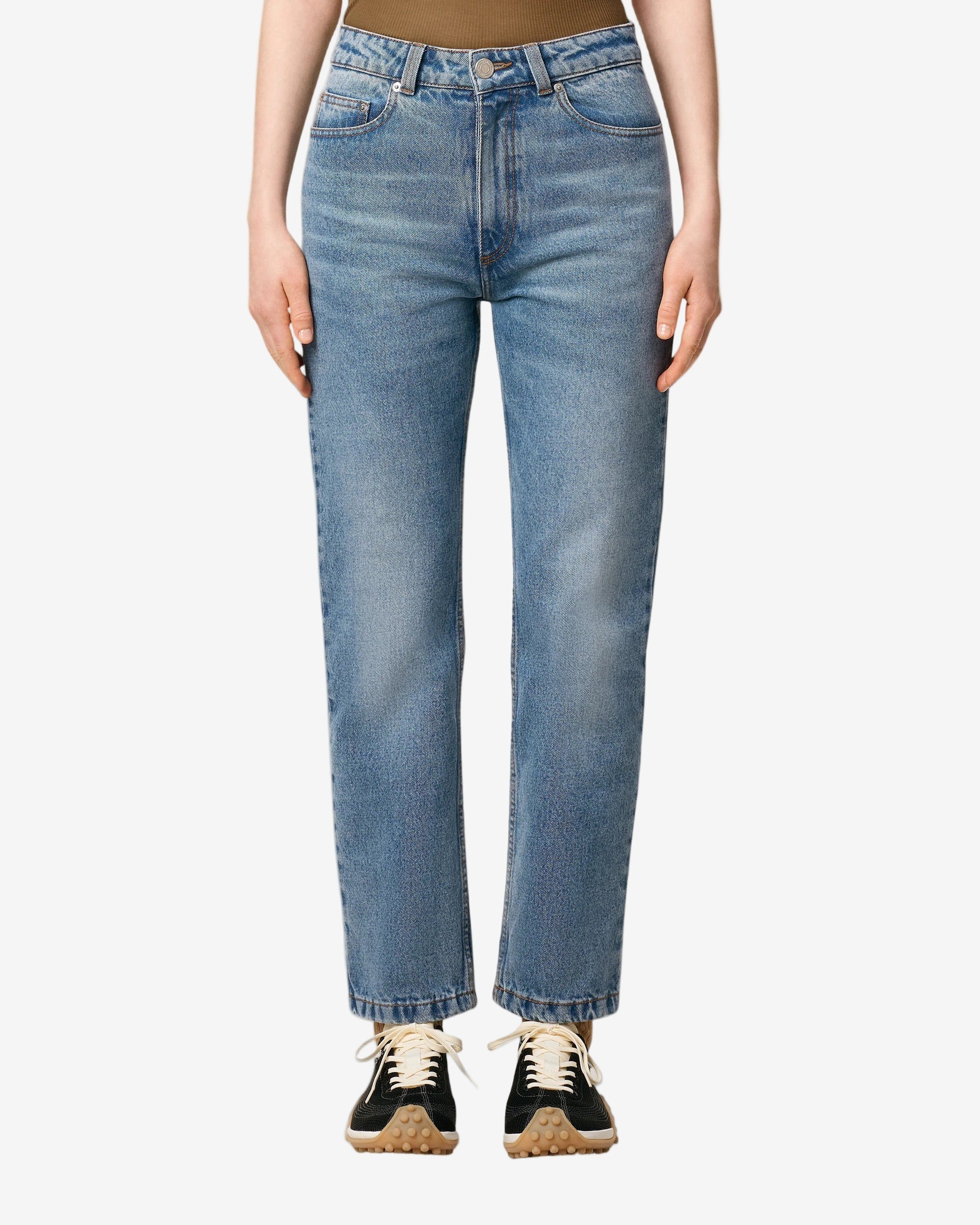 Person wearing blue jeans on a plain background