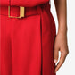 Red outfit with a gold belt on a neutral background
