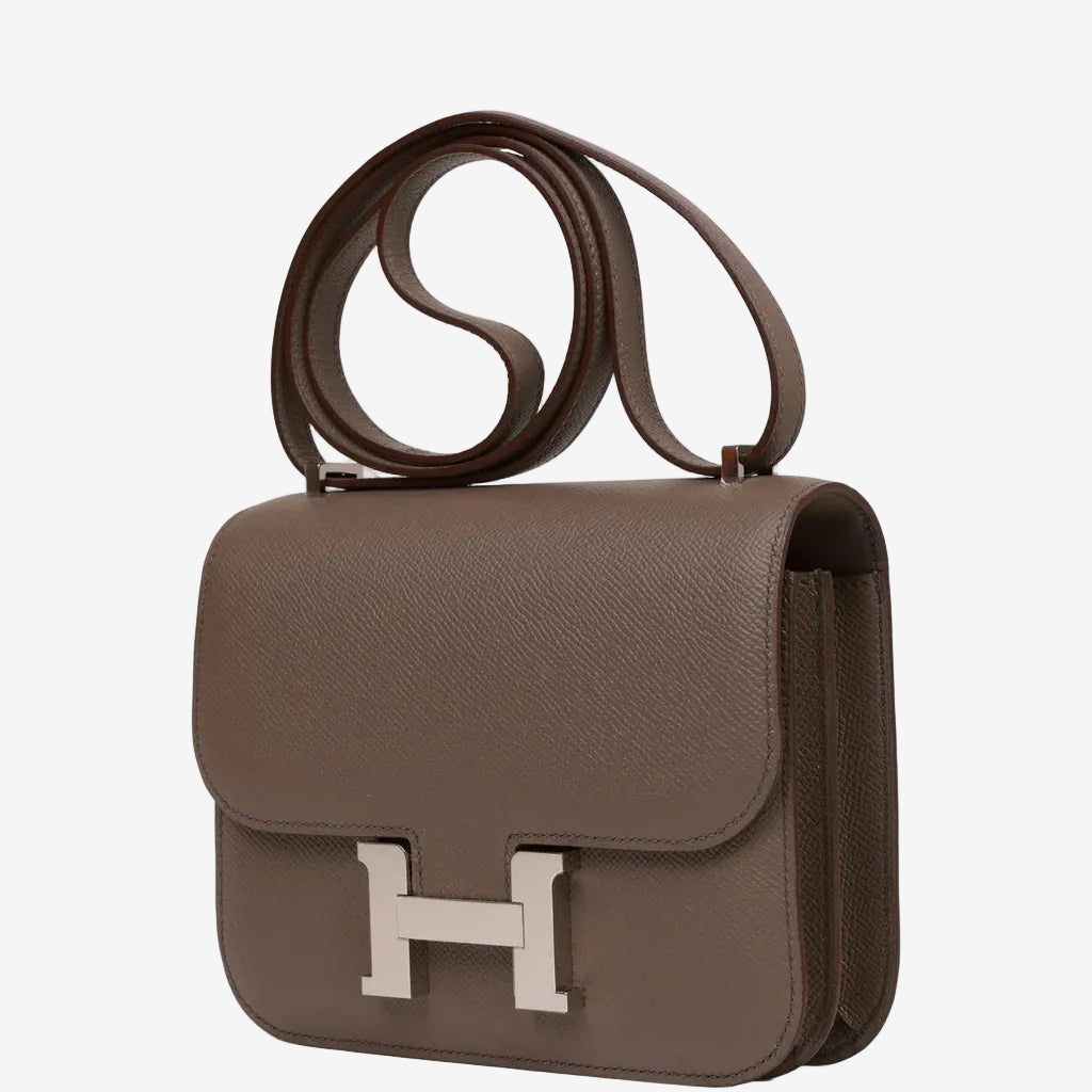 Brown handbag with a silver clasp on a white background hermes