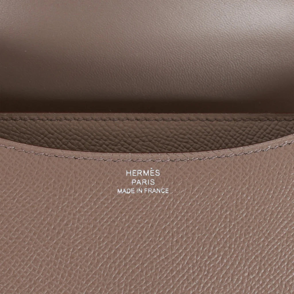 Brown handbag with a silver clasp on a white background hermes