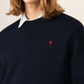 Black sweater with a red heart emblem on a beige background