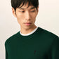 Green sweater on a beige background