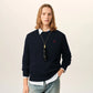 Black sweater with a red heart emblem on a beige background