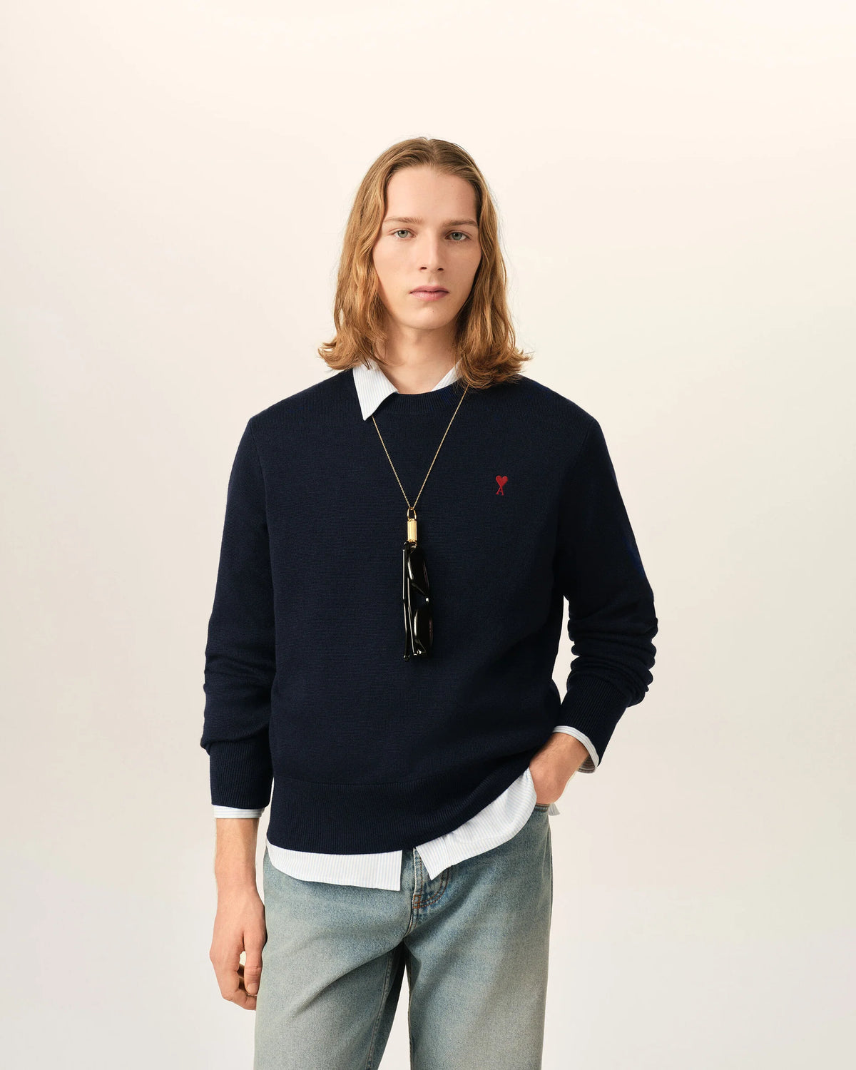 Black sweater with a red heart emblem on a beige background