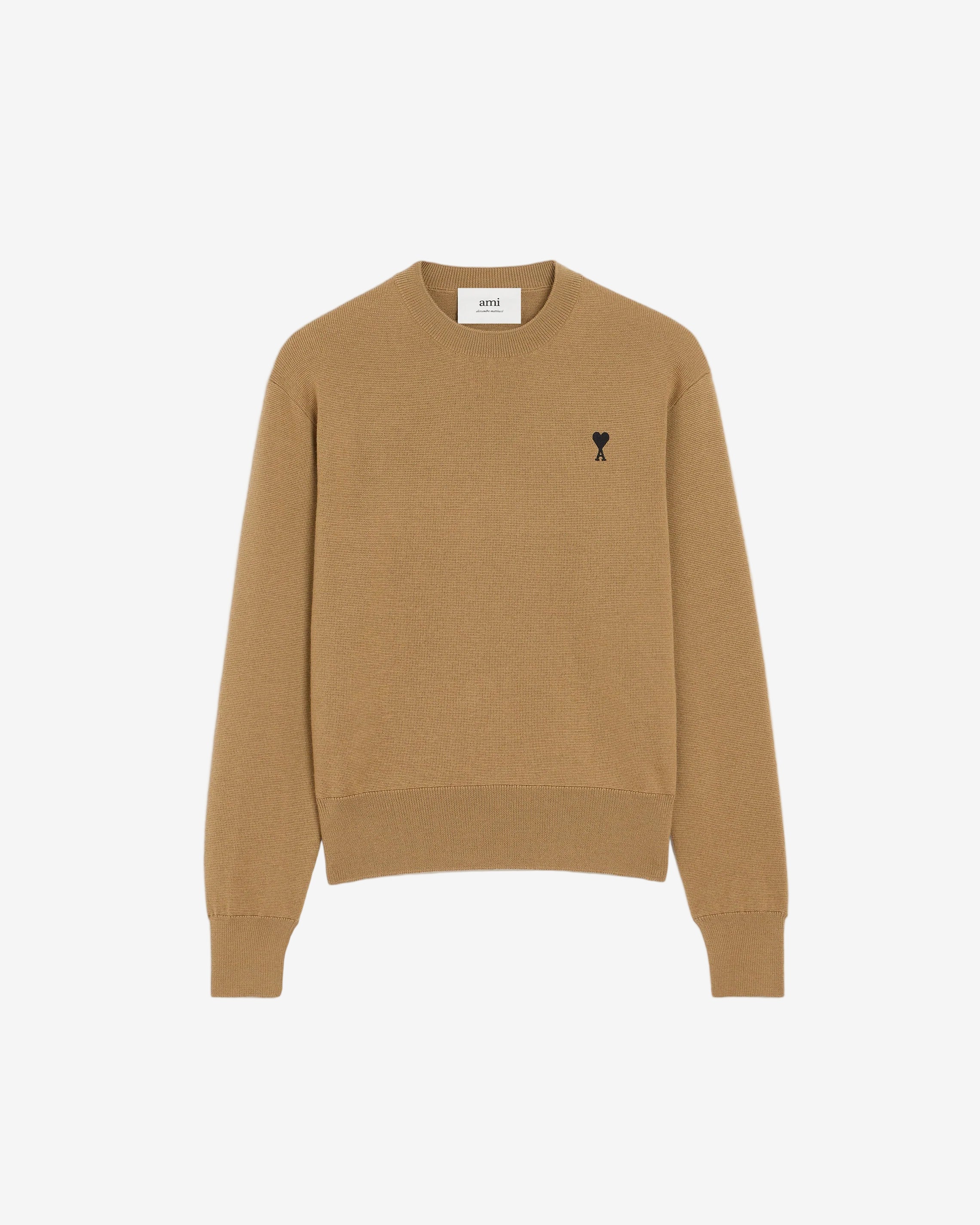 Beige sweater with a small logo on a beige background