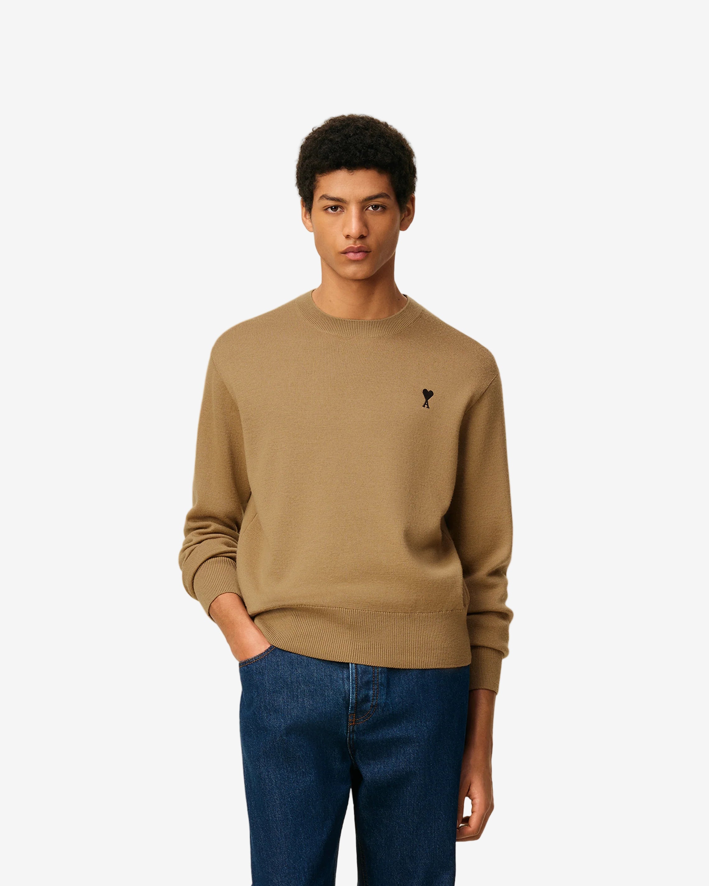 Beige sweater with a small logo on a beige background