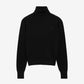 Black turtleneck sweater on a beige background