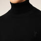 Black turtleneck sweater on a beige background