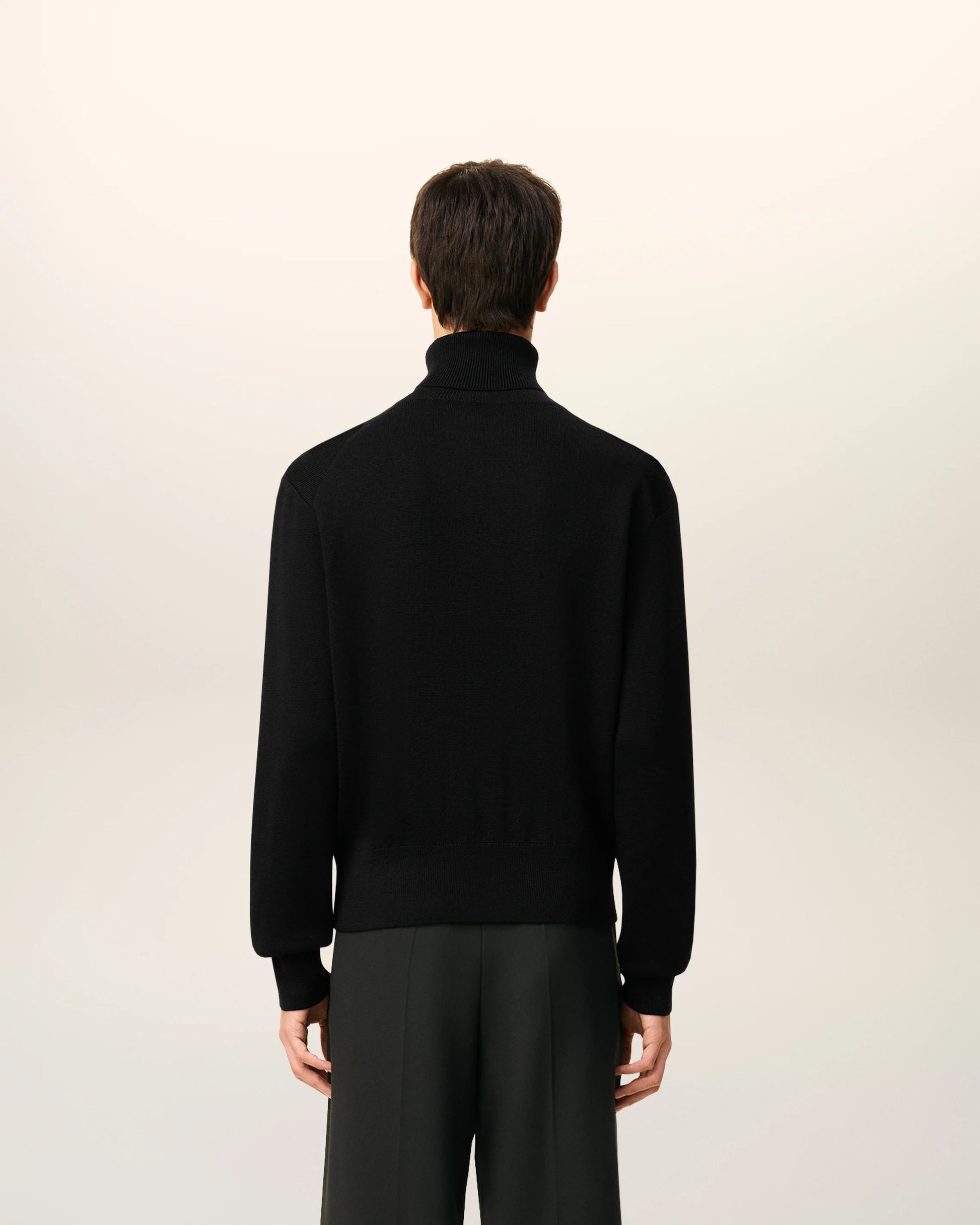 Black turtleneck sweater on a beige background