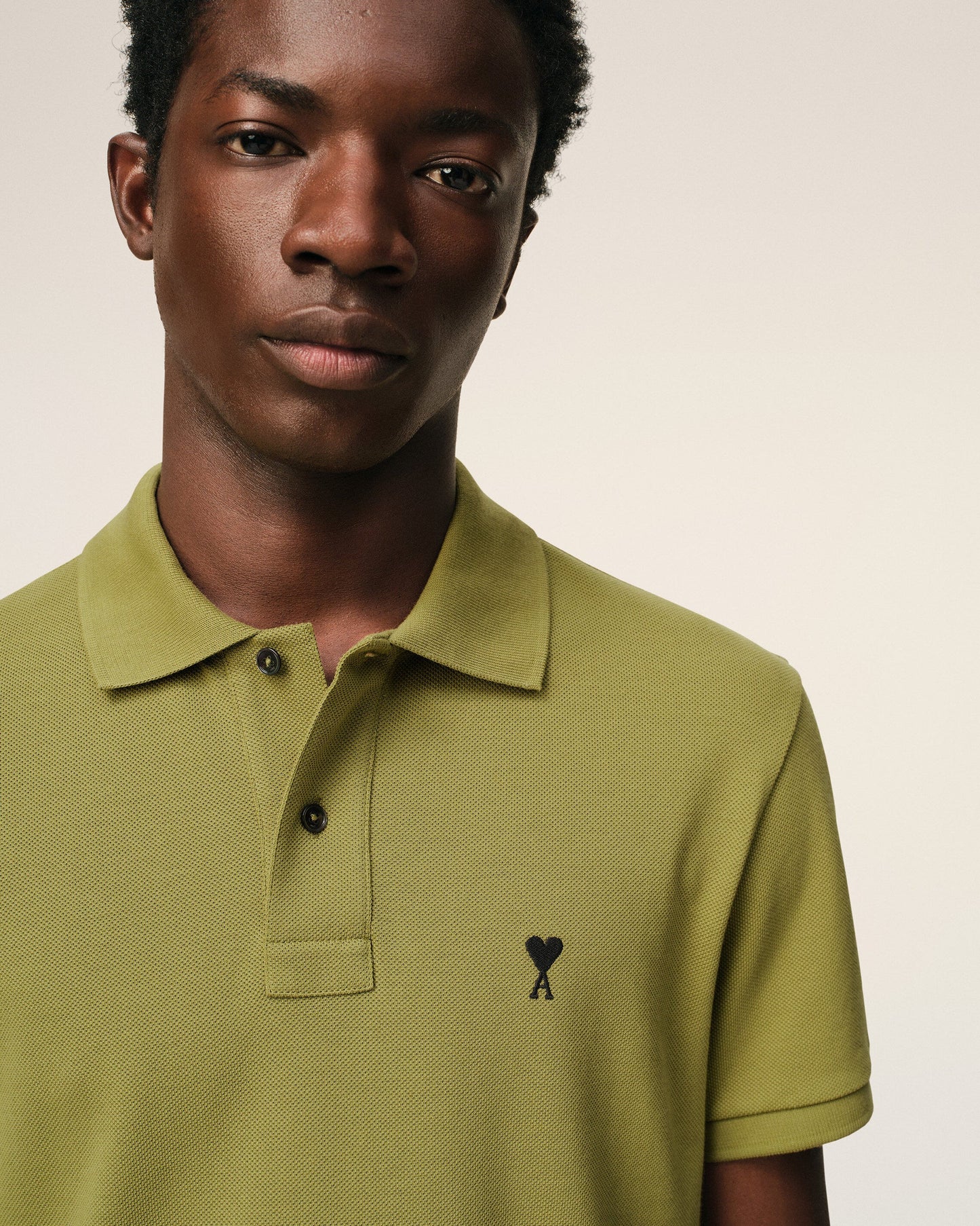 Green polo shirt on a light beige background ami paris