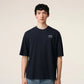 Navy blue t-shirt with 'ami' logo on a beige background ami paris