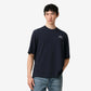 Navy blue t-shirt with 'ami' logo on a beige background ami paris