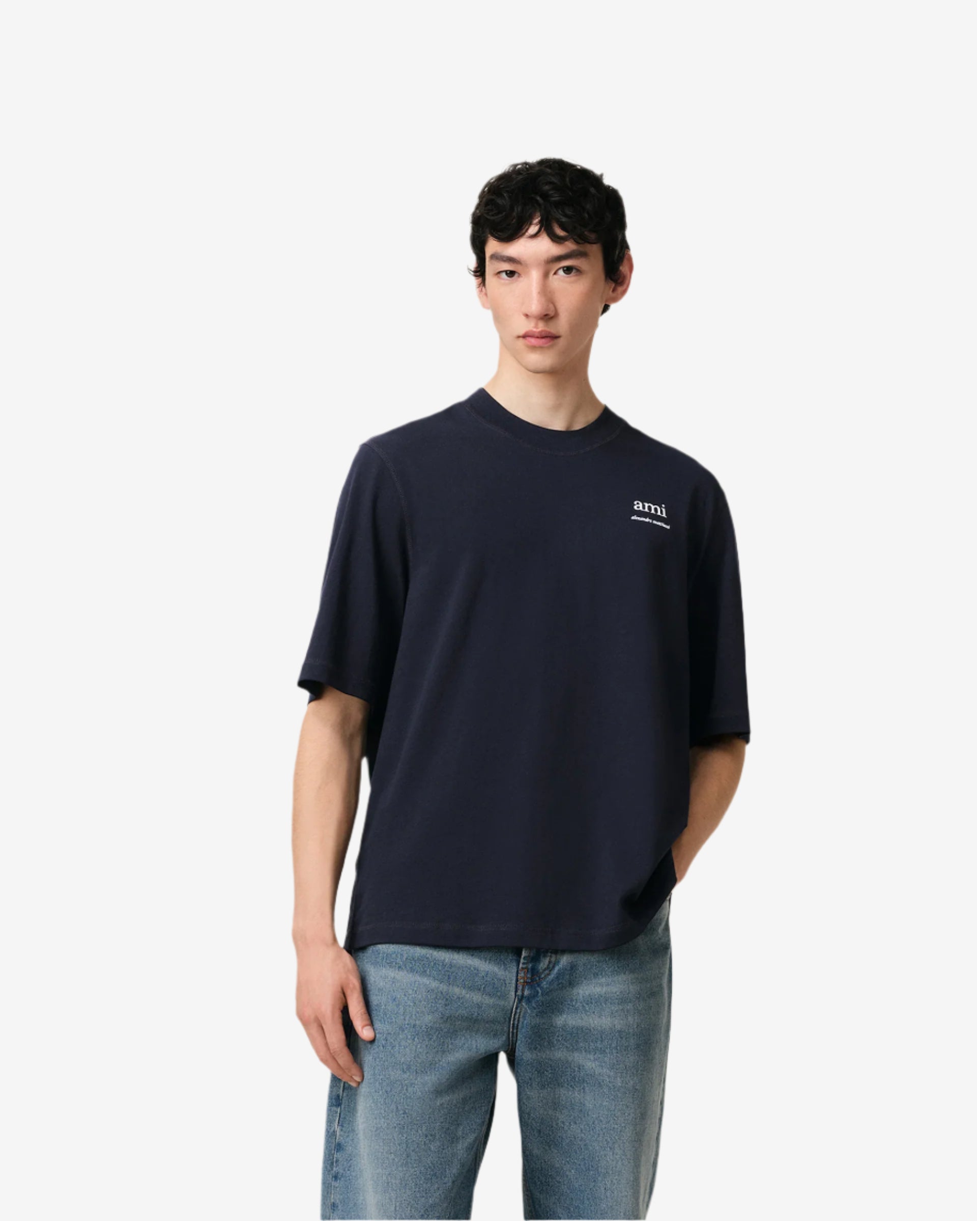 Navy blue t-shirt with 'ami' logo on a beige background ami paris