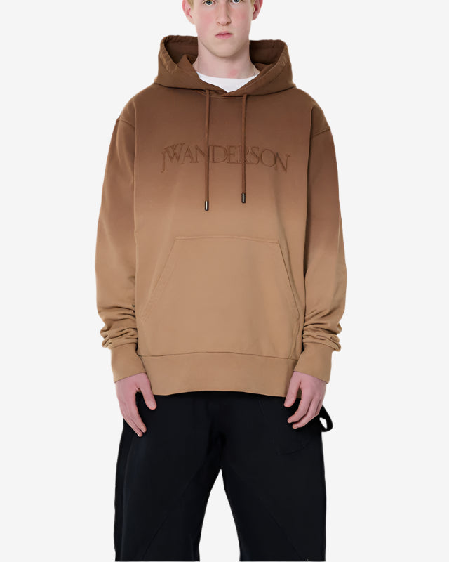 Person wearing a brown hoodie with 'WANDERSON' branding on a white background
