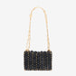 Black woven handbag with gold chain strap on a white background