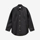 Black leather jacket with button details on a light gray background